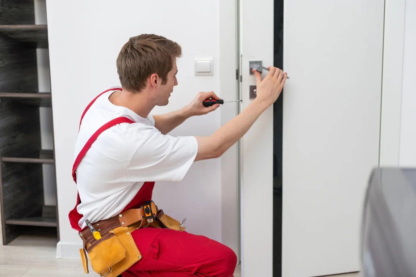 Artisan serrurier du collectif renforçant une porte d'entrée en Essonne